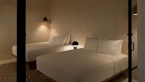 A hotel room with two beds, a nightstand, and a wall-mounted light fixture. - Narrativ Lofts -Numen- Stylish Hideaway (Campeche)