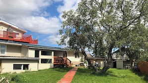 A residential area with a red pathway leading to a house with a porch. - Bear Paw Inn (Dillingham)