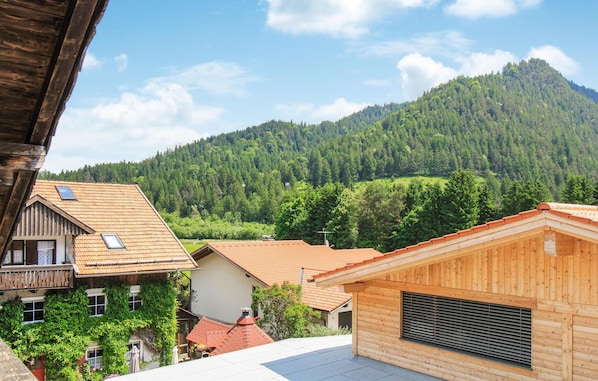 A wooden cabin with a sloped roof, surrounded by a forested mountain backdrop. - Lovely apartment in Pfronten with sauna (Pfronten)