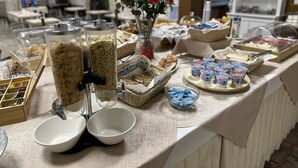 A buffet table with various food items, including cereal, eggs, and dairy products. - Hotel Morolli Rimini (Rimini)