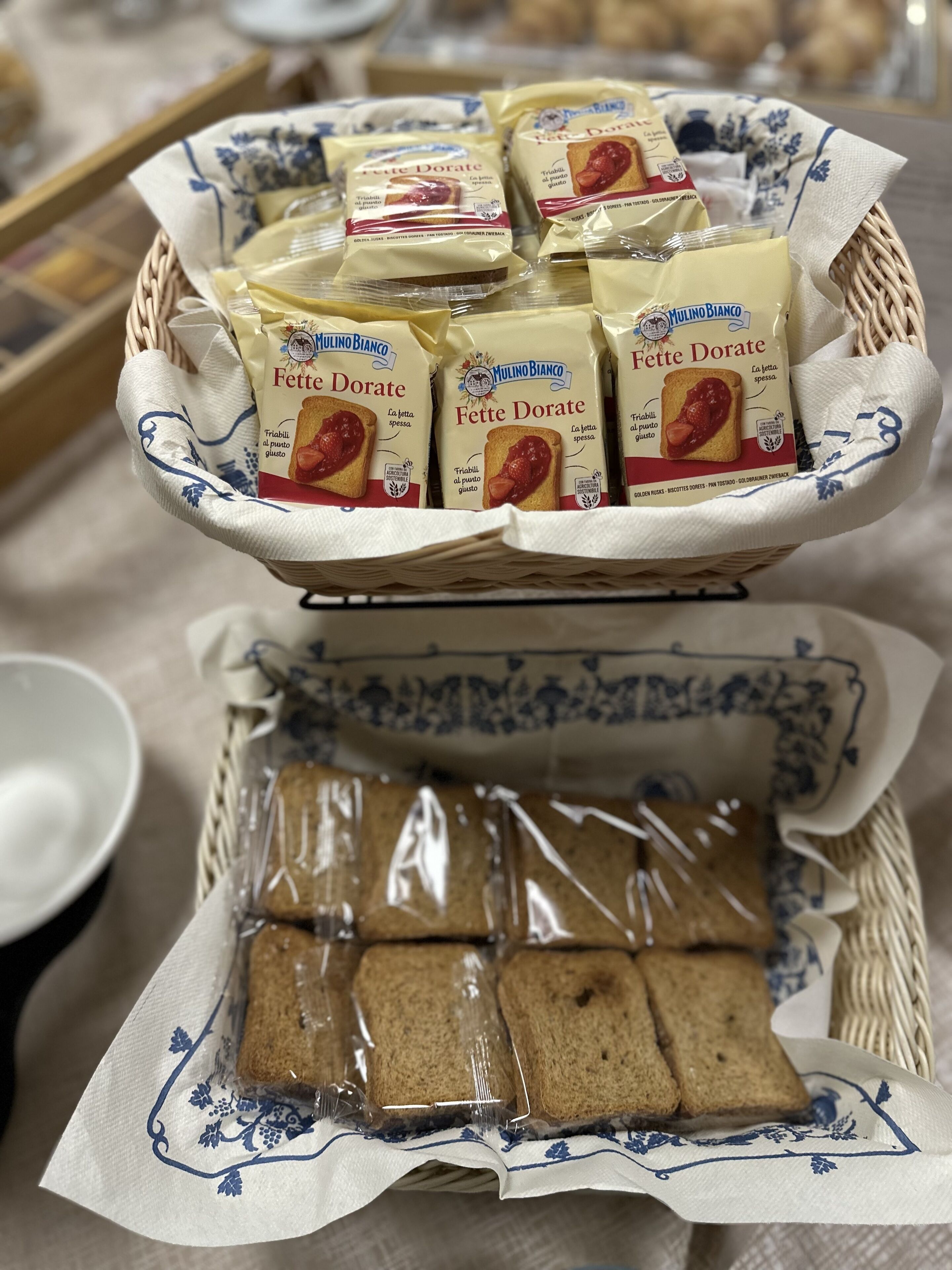 A basket containing packets of Fette Dorate and Milino Bianco bread, along with a tray of sliced bread.