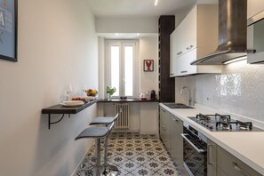A compact kitchen with a gas stove, a sink, and a window. - Belfanti, 6 - Bright apartment with view (Milano)