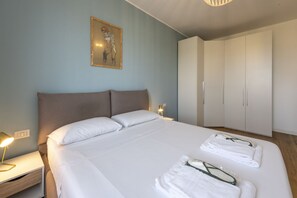 A bedroom with a bed, nightstands, a wardrobe, and a painting on the wall. - Belfanti, 6 - Bright apartment with view (Milano)