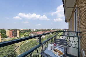 A balcony with a table, a chair, and a plate of food. - Belfanti, 6 - Bright apartment with view (Milano)
