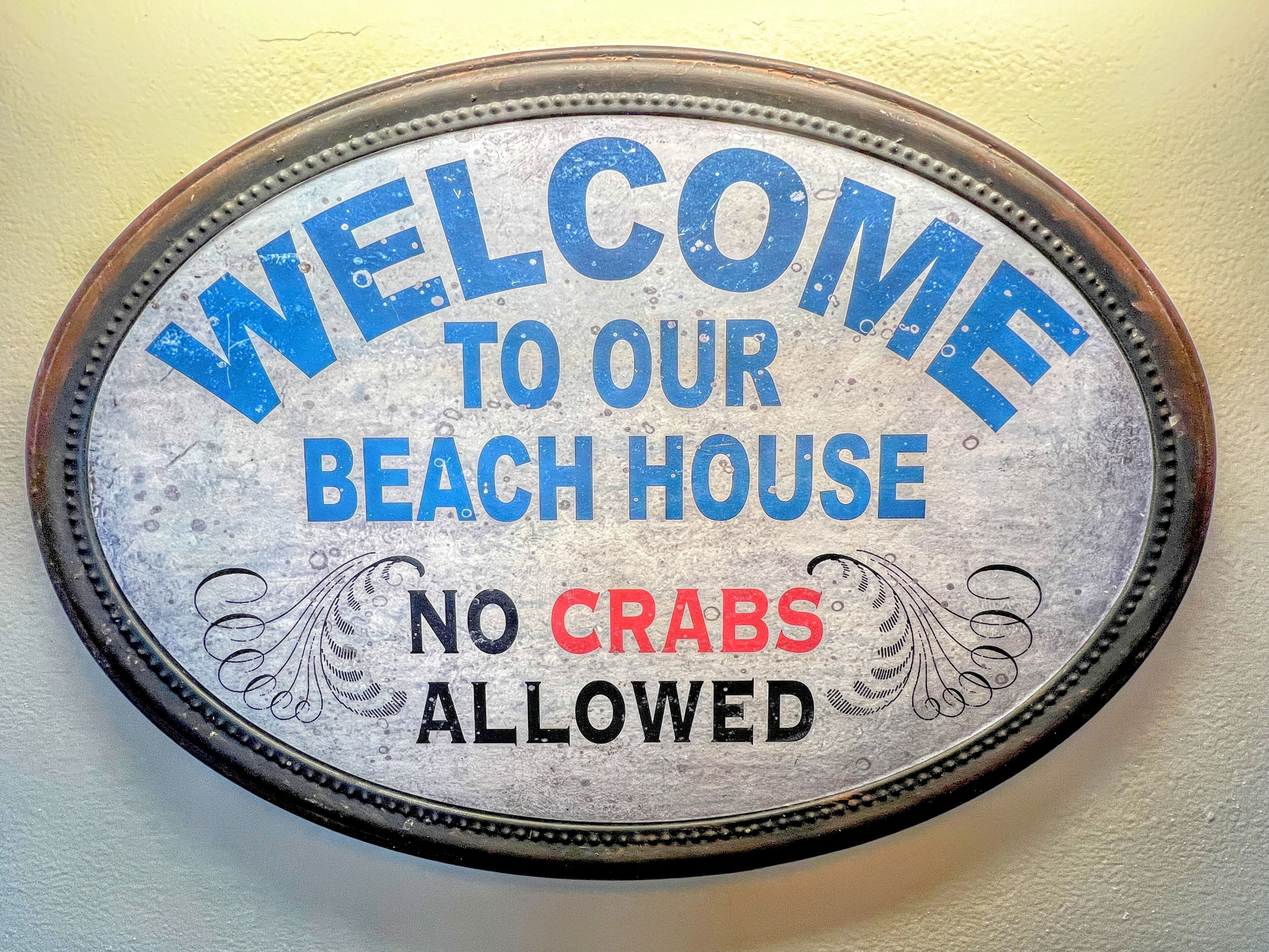 A welcome sign for a beach house with a no crabs allowed policy.