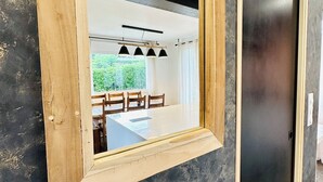 Une pièce avec un mur à la texture sombre, une fenêtre à cadre en bois et une porte noire.