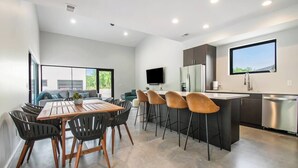 A modern kitchen with a dining area, a large window, and a flat-screen TV. - 90 min from Chicago, Pool, Hot Tub, Pet Friendly come enjoy After Dune Delight (Stevensville)