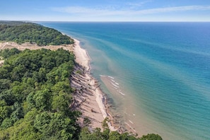 A coastal landscape with a beach and forested area.