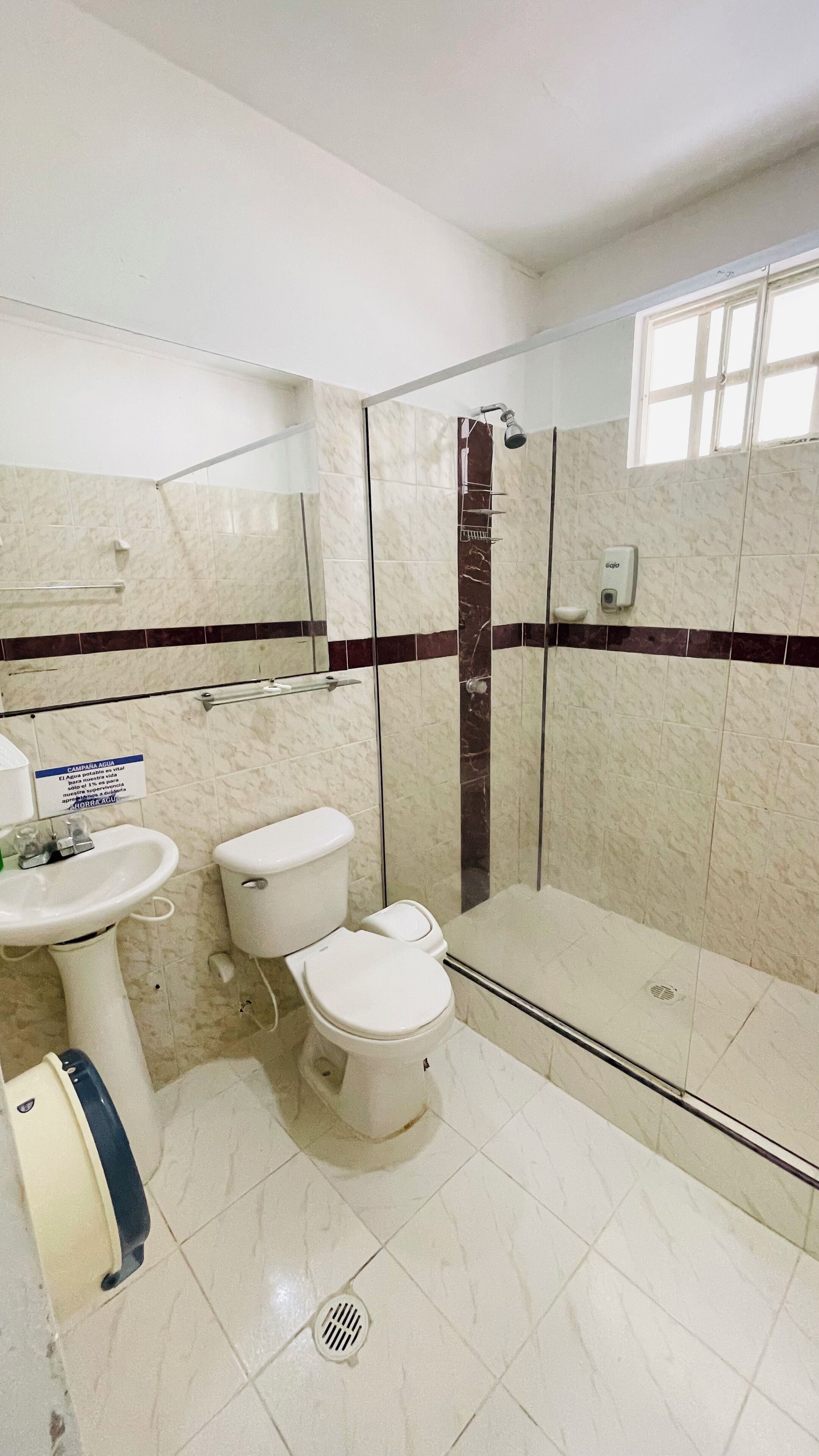 Un baño con ducha, inodoro y lavamanos.