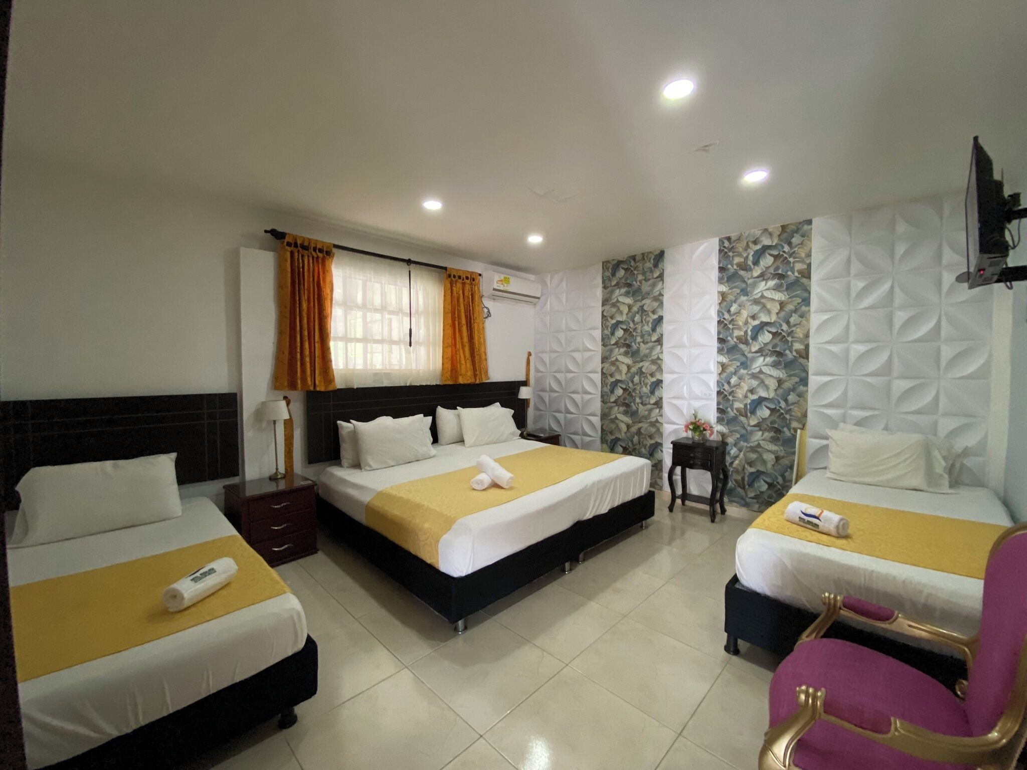 A hotel room with two beds, a desk, and a chair.