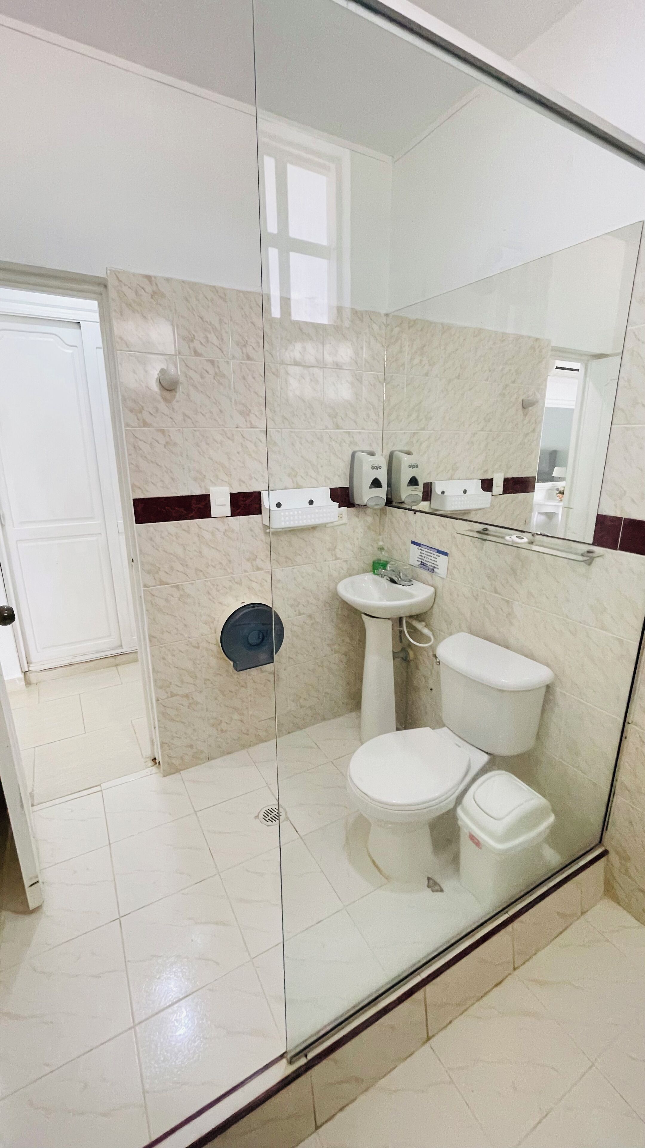 A modern bathroom with a glass shower enclosure, a sink, a toilet, and a bidet.