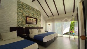 A hotel room with two beds, a stone wall with a floral pattern, a framed picture, and a view of greenery outside. - Hotel Rosalinda Campestre del Llano (Villavicencio)