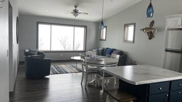 Enjoy meals and relaxation in this well-designed kitchen and dining area, featuring a central island, dining table, and refrigerator.