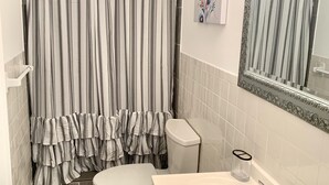 A bathroom with a toilet, sink, and shower curtain.