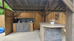 A rustic outdoor kitchen with a stone countertop and a wooden wall. - Niagara Luxury villa-Breakfast, pool, water view (Niagara Falls)