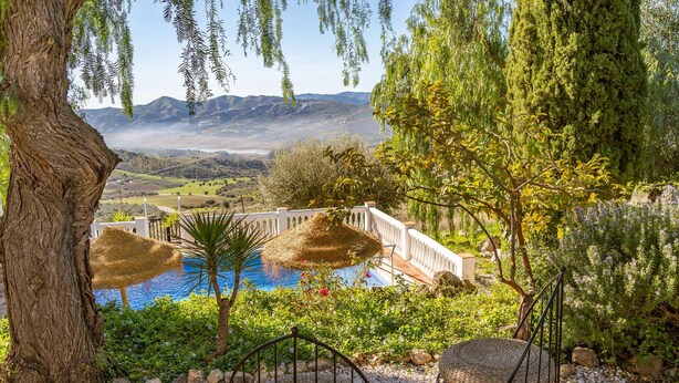 A pool area with a view of a mountainous landscape, surrounded by trees and a white fence. - Beautiful home in Periana (Periana)