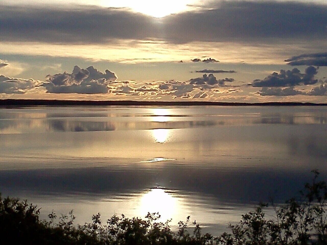 Ruhige Wasseroberfläche spiegelt den Himmel.