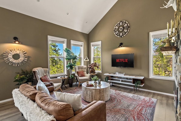 Una sala moderna con un sofá marrón, una mesa de centro y un televisor montado en la pared.