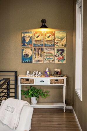 A room with a wall-mounted poster featuring various Colorado ski destinations. - LUXE MTN Retreat, EPIC views, Hot tub, STARGAZING Bed, Firepit, Red Rocks (Bailey)