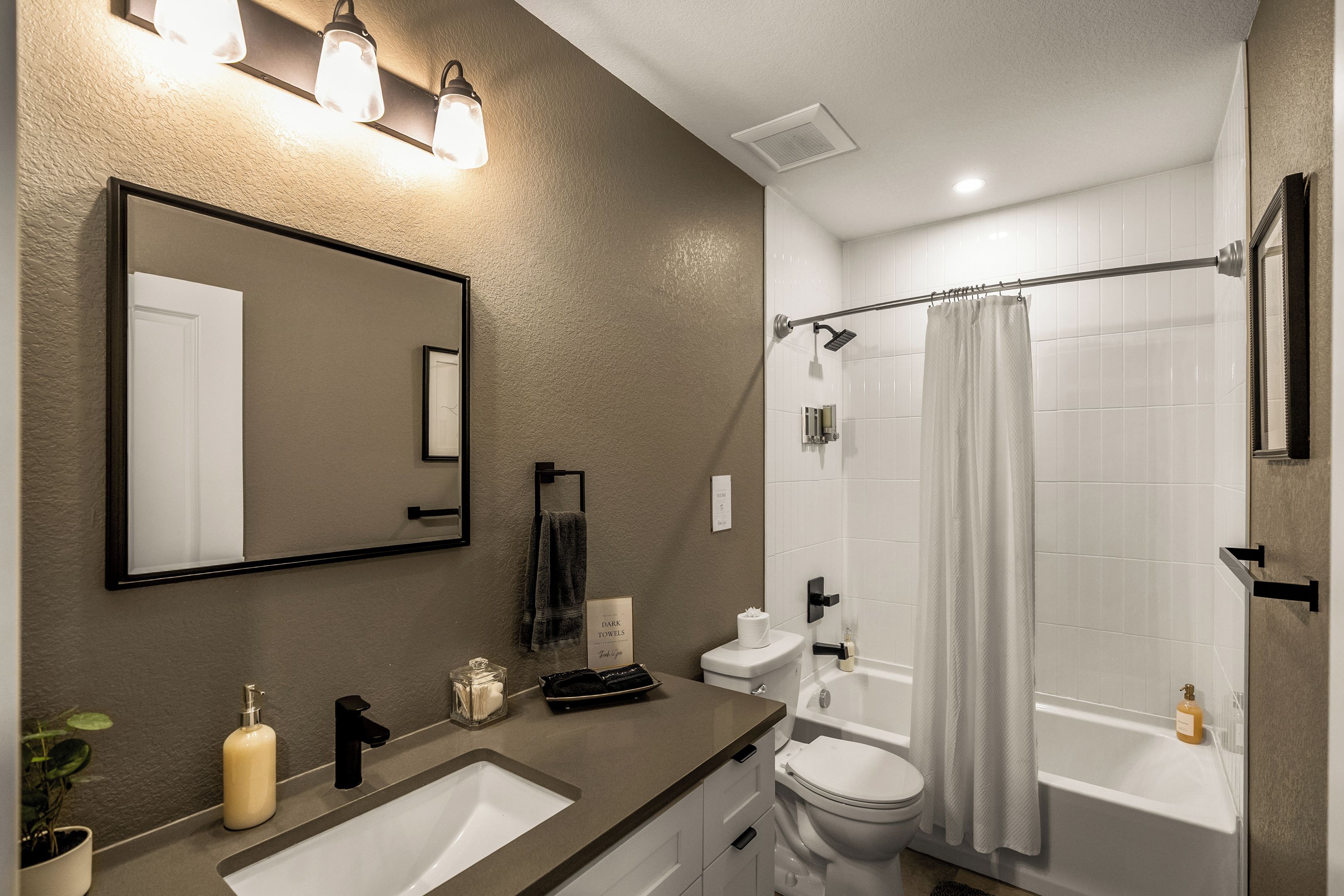 Ein modernes Badezimmer mit Waschbecken, Toilette, Badewanne und Duschvorhang.