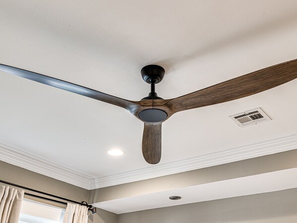 A ceiling fan with a wooden blade and a central light fixture.