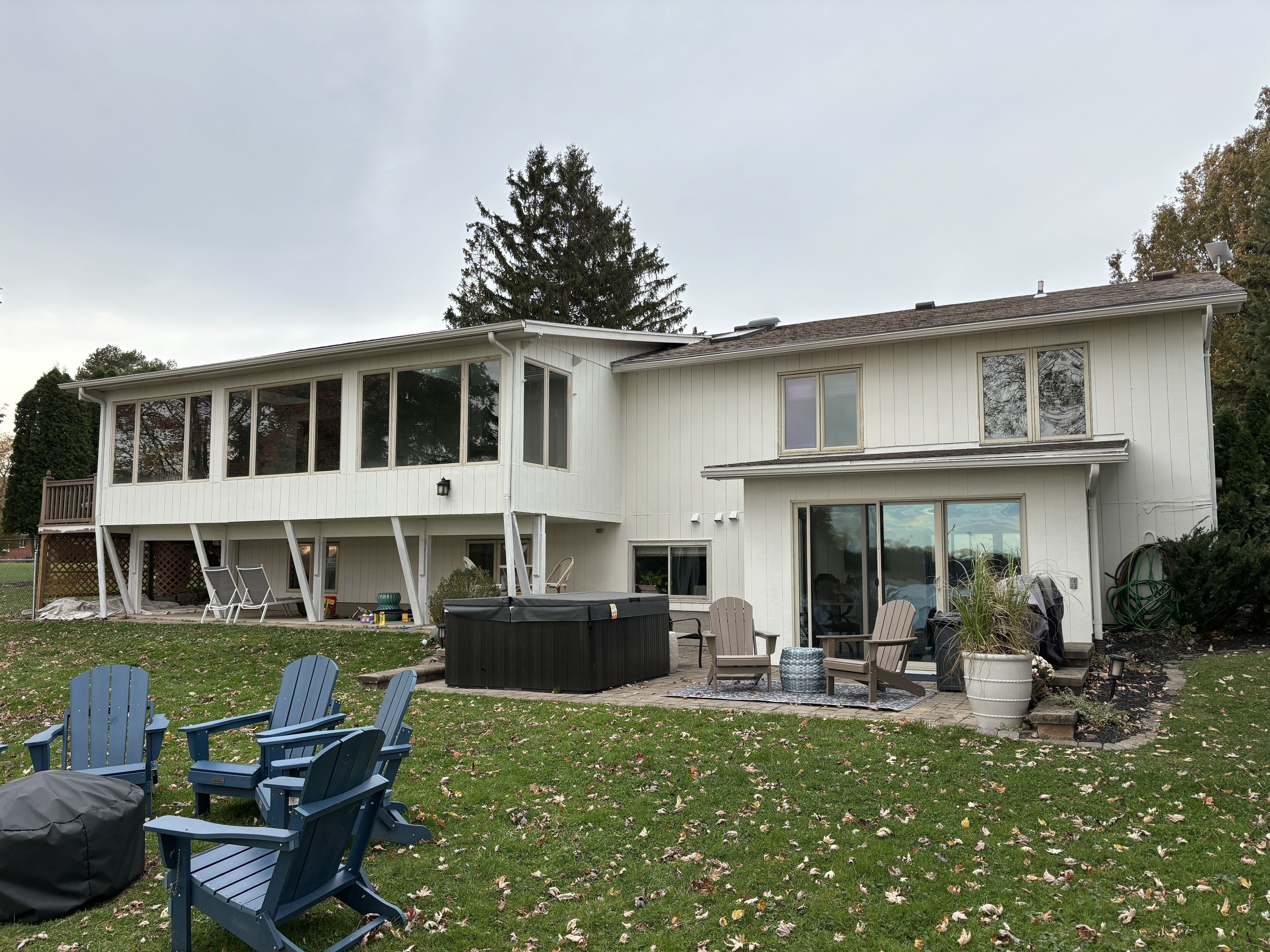 A two-story house with a covered deck and a patio area.