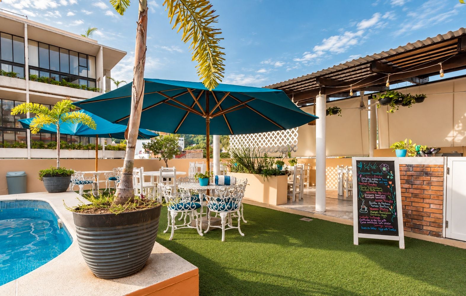 An outdoor patio area with a pool, seating, and a chalkboard menu.