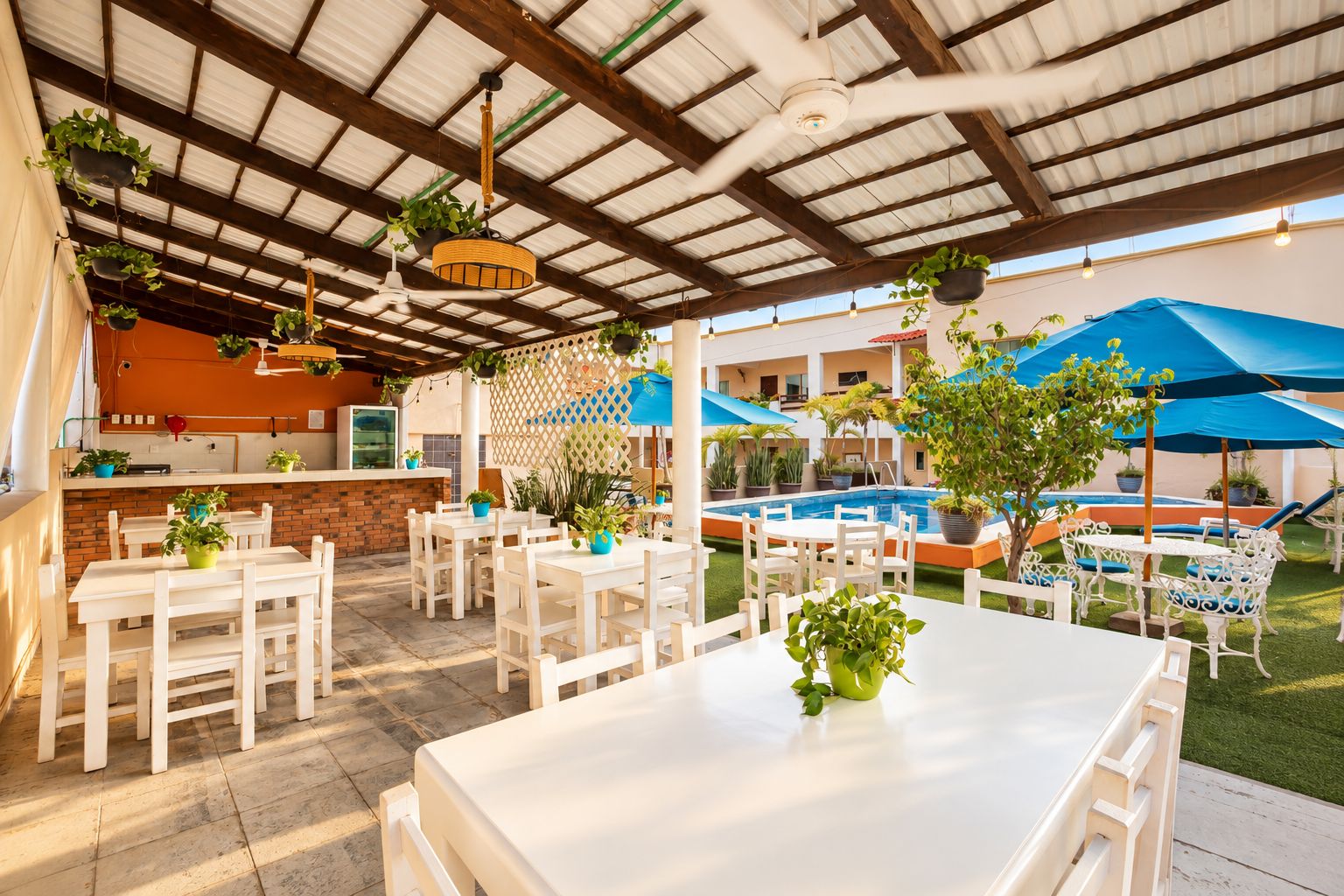 An outdoor patio with white tables and chairs, a pool, and potted plants.