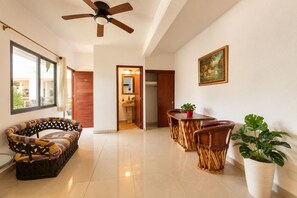A spacious living area with a sofa, dining table, chairs, and a ceiling fan. - HOTEL PUEBLITO VALLARTA (Puerto Vallarta)
