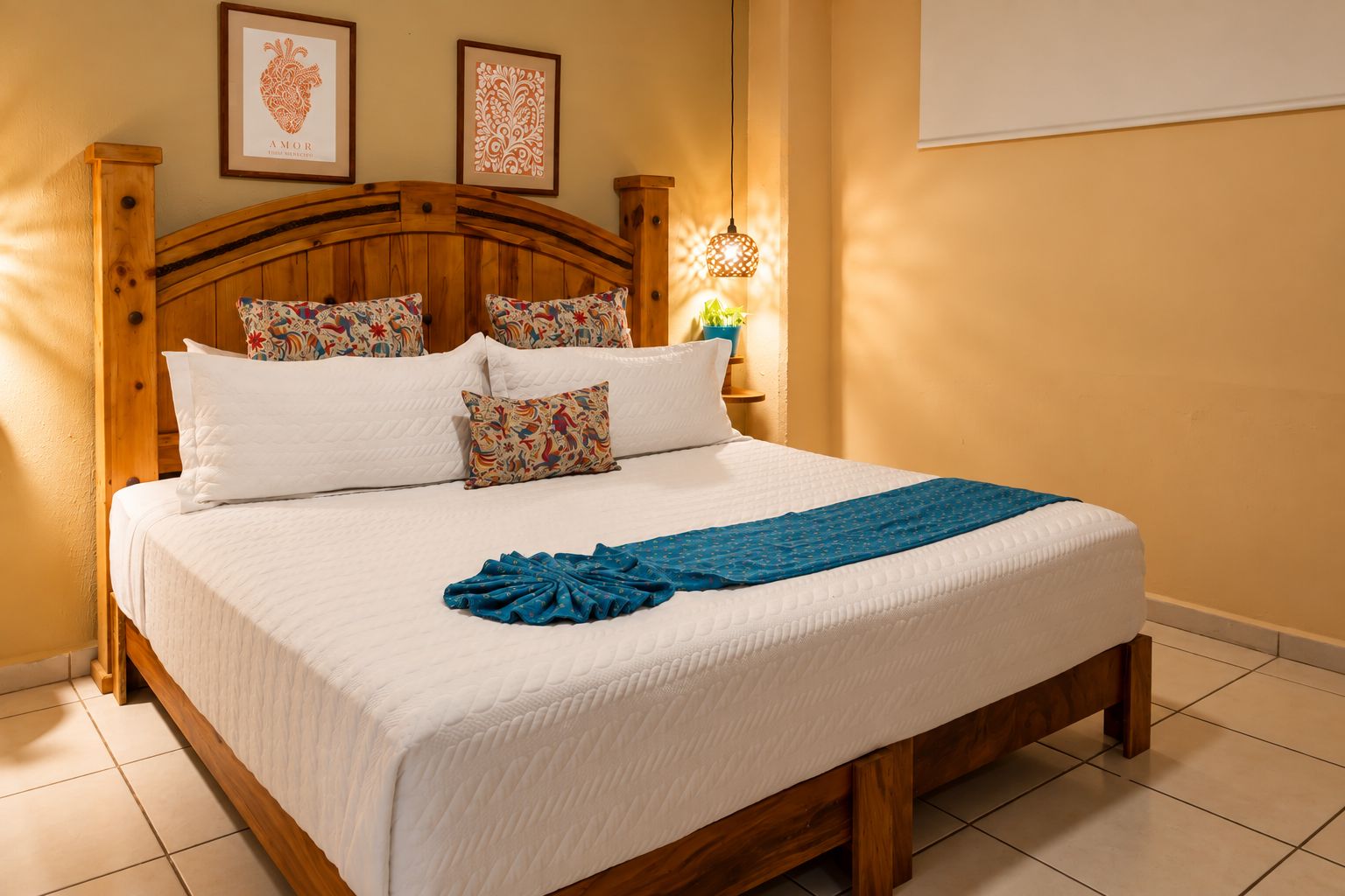 Una cama bien hecha con cabecera de madera, ropa de cama blanca y una manta azul.