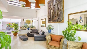 A spacious living area with a large painting, multiple sofas, and potted plants. - HOTEL PUEBLITO VALLARTA (Puerto Vallarta)