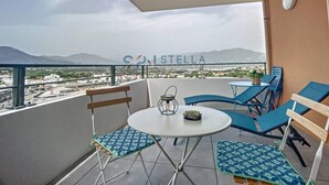 A balcony with a table, chairs, and a view of the city and mountains. - Superb T2 Splendid view Ajaccio (AJACCIO)
