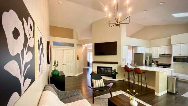 A modern living room with a gray sofa, a wooden coffee table, and a chandelier. - Ultra-Chic Modern Mid-Century Home in Bethany (Portland)