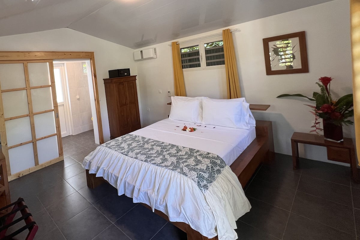 Un dormitorio con cama, armario, escritorio y televisor.