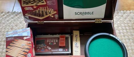 A wooden box containing various board games including Dama & Scacchi, Dominoes, Scrabble, Backgammon, and Texas Hold'em Poker.