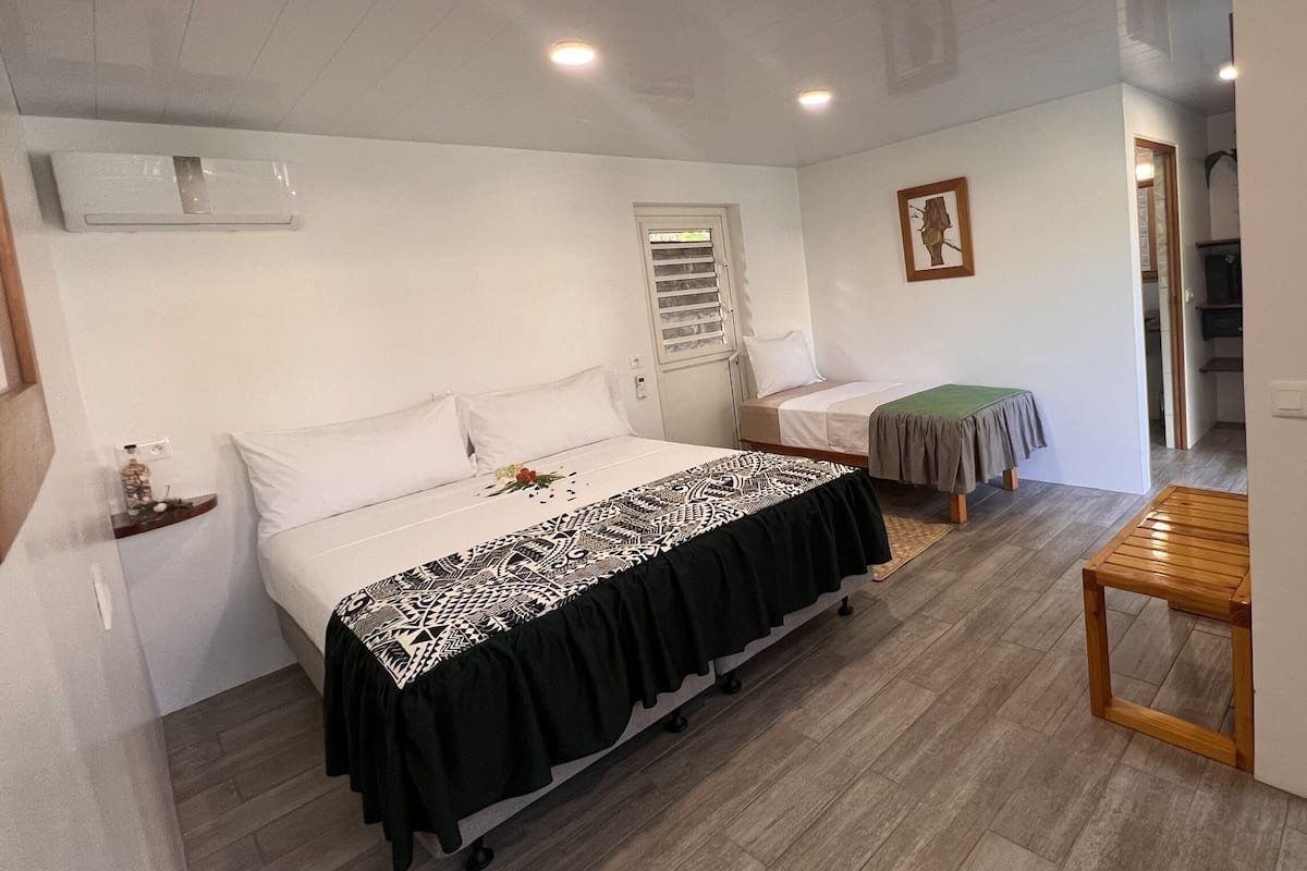 Un dormitorio con cama, mesita de noche y una pequeña mesa de madera.