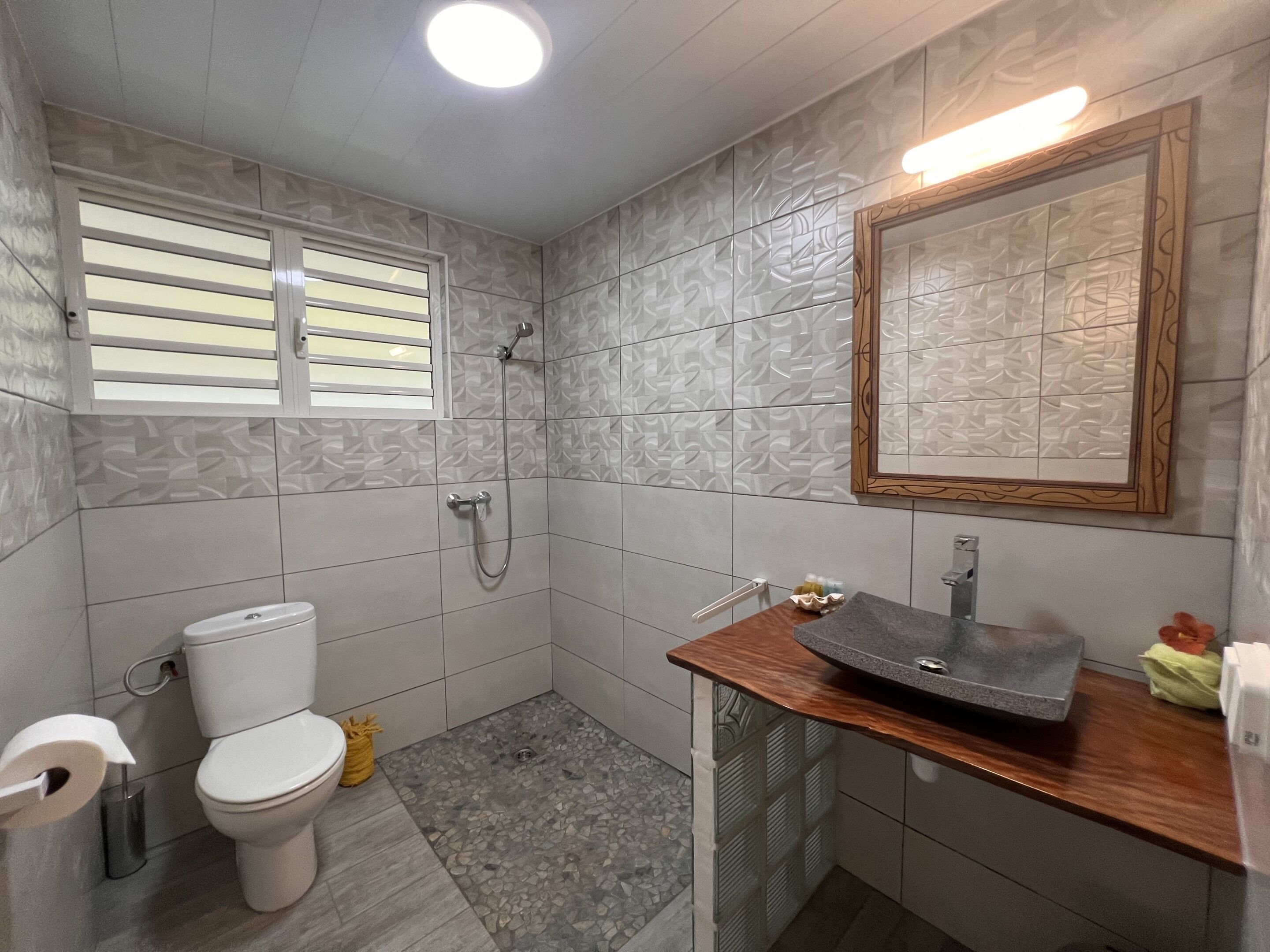 Une salle de bain avec des toilettes, une douche et un lavabo.
