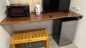A kitchenette with a microwave, coffee maker, and a small refrigerator.