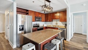 A modern kitchen with granite countertops, stainless steel appliances, and wooden cabinets.