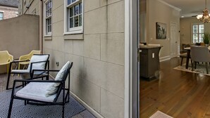 Un interno moderno con zona pranzo, angolo cottura e balcone con posti a sedere esterni.