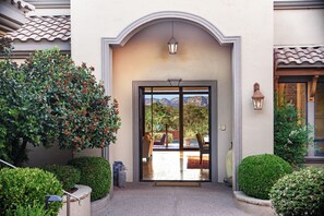A building entrance with a glass door, a small patio area, and a view of mountains.
