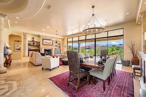 A spacious living area with a fireplace, comfortable seating, and a large dining table.