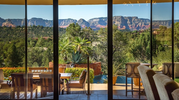 Una terraza con asientos al aire libre y vistas a un paisaje montañoso.