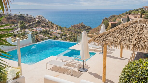 A pool area with a view of the sea, lounge chairs, and a thatched umbrella. - CostaBlancaDreams - Villa Paraguana in Benitachell (Benitachell)