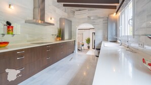 A modern kitchen with a large island, dark wooden cabinets, and a white countertop. - CostaBlancaDreams - Villa Paraguana in Benitachell (Benitachell)