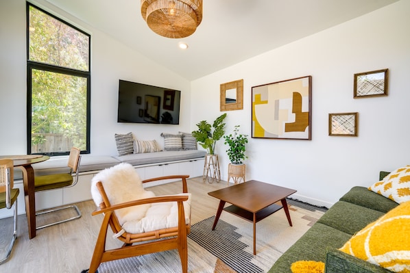Relax in a spacious living room with a sofa, chairs, and flat-screen TV.