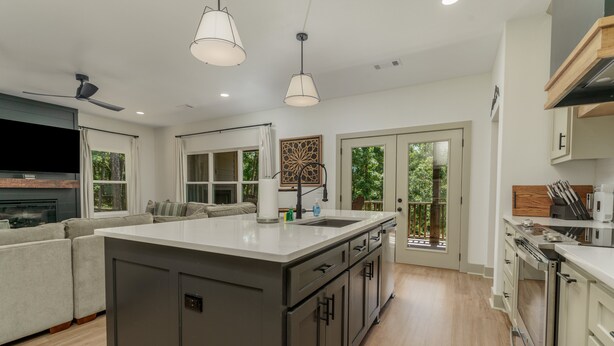 Una cocina moderna con una isla grande, electrodomésticos integrados y un comedor con sofá.