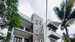 Un moderno edificio de varios pisos con un camino adoquinado, balcones y fachada de piedra.