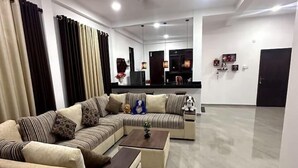 Una sala de estar moderna con un sofá modular, una mesa de centro y una zona de televisión.