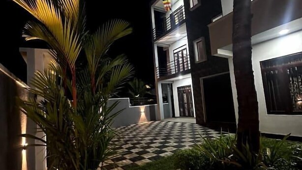 Un moderno edificio de dos plantas con un patio a cuadros, iluminado con luz ambiental.